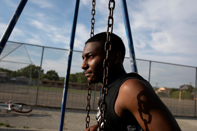 Sir sits on the swings at Sobrante Park behind Madison Park Academy. Photo by Anne Wernikoff, CalMatters