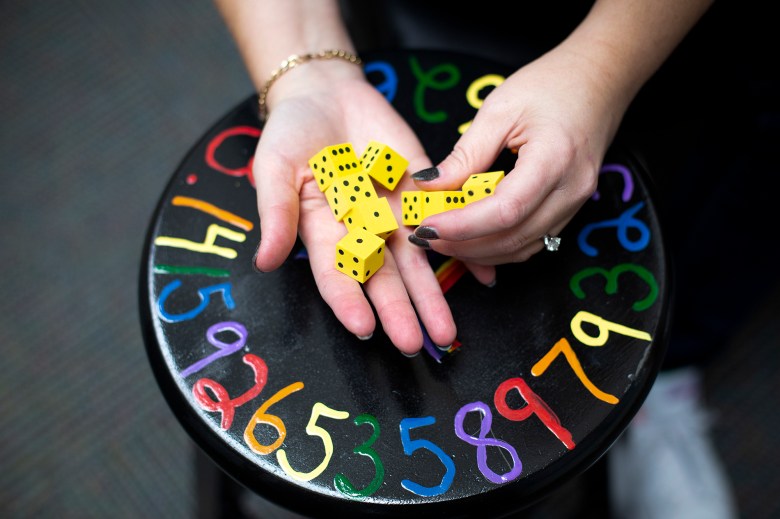 Rebecca Parison holds a set of dice she uses to teach math to her students at the Hueneme Elementary School District in Oxnard on Nov. 12, 2021. Photo by Julie Leopo for CalMatters